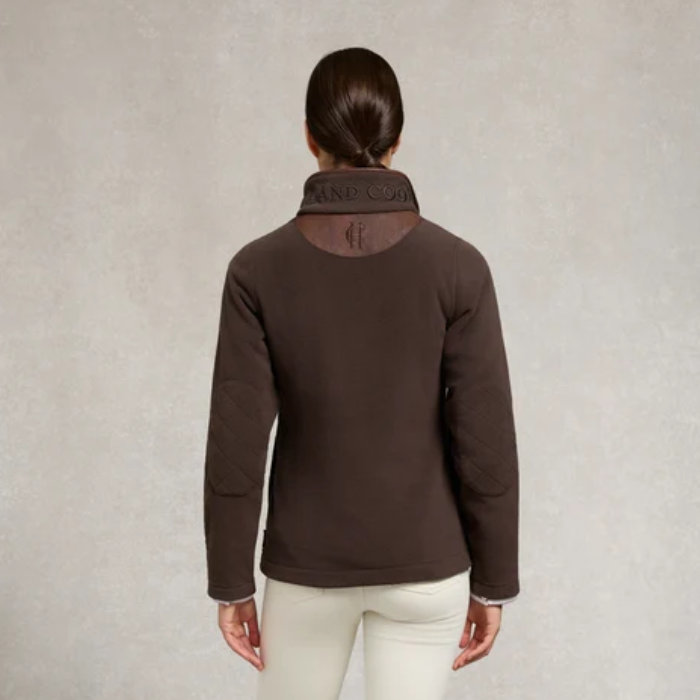 Holland Cooper Ladies Country Fleece Quarter Zip Variant Chocolate. Back of lady wearing a brown fleece jumper with a HC logo against a grey background. 
