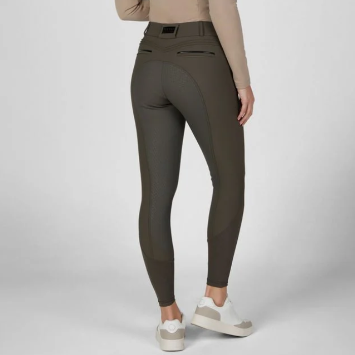 Pikeur AW26 Ceelina Matrixgriptex Breeches Variant Deep Khaki. A model from the back wearing high-waisted equestrian riding breeches in olive green, paired with a beige long-sleeve top and white sneakers, against a light gray studio background.