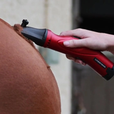 Red and black grooming tool being used on a horse's body.