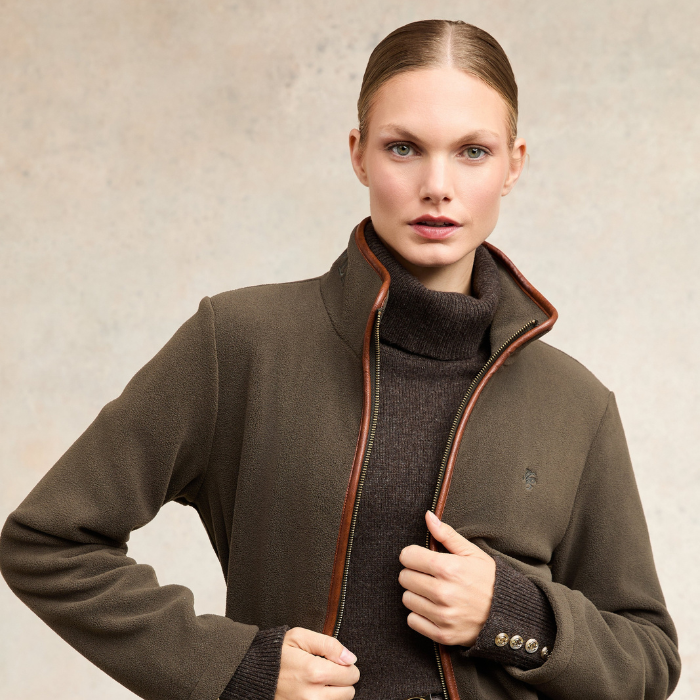 Holland Cooper Country Longline Fleece Varient Khaki. Woman wearing a high collar khaki jacket with a small HC logo on the chest.