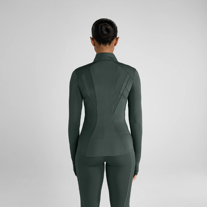 person with pale green jacket on grey back ground