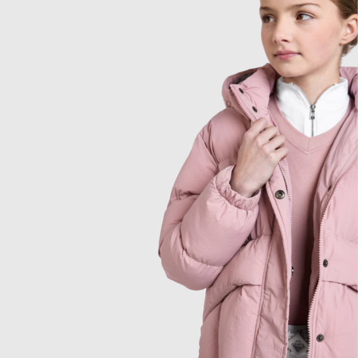 Child wearing a pink puffer coat on a light grey background