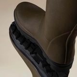Le Chameau Ladies Vierzonord Neoprene Lined Wellies Variant Chameau Green. A close-up of a dark brown rubber rain boot with a thick, black treaded sole, shown against a solid beige background.