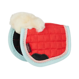 Red quilted equestrian pad with white fur on a white background