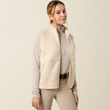Ariat Yth Laviolette Full Zip Vest Varient Almond Milk. Lady wearing a cream fleece gilet with matching beige trousers on a light background.