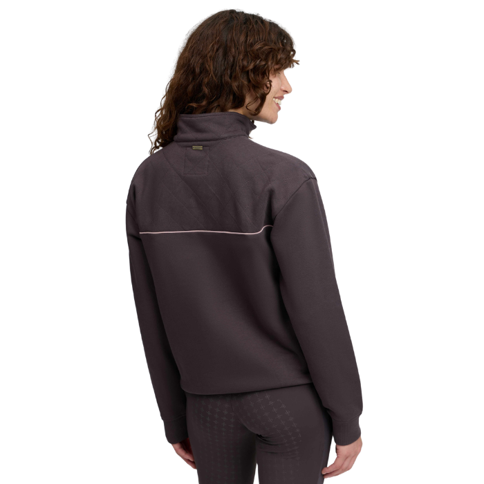 Back of lady wearing a brown jumper with pink piping against a white background. 