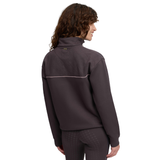 Back of lady wearing a brown jumper with pink piping against a white background. 