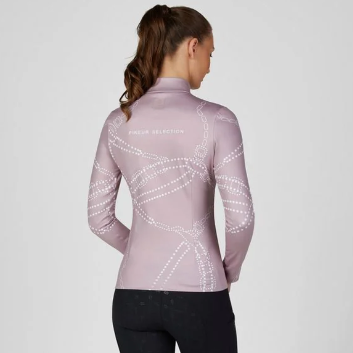 Pikeur AW26 Zip Print Shirt Collection Variant Ash Mauve. A woman shown from the back wearing a fitted long-sleeve athletic top in dusty pink with a white dotted chain-like graphic pattern across the back and sleeves. The brand name 'PIKEUR SELECTION' is printed in small white text near the upper back.