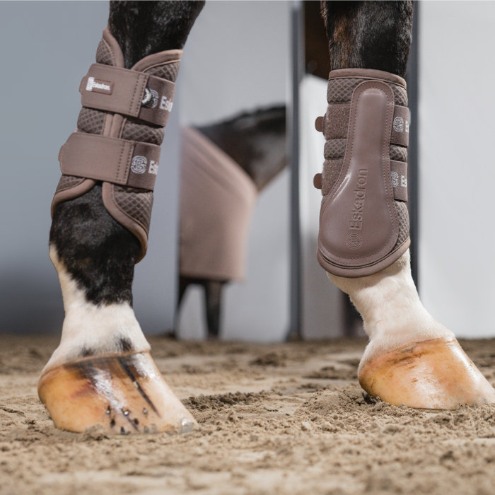 A photo of two horses legs wearing brown boots with 'Eskadron' branding. 