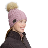 Lady wearing a pink knit beanie with a brown logo against a white background. 