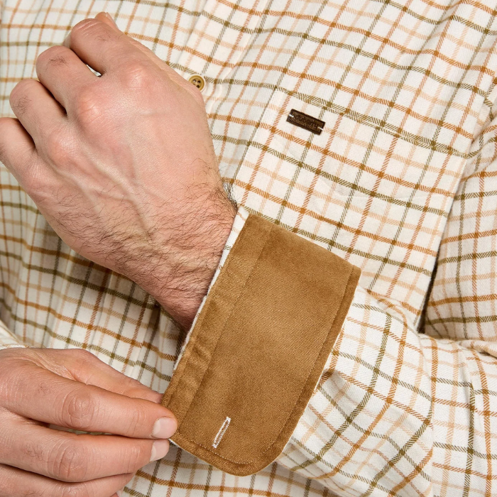 Dubarry Men's Corrib Shirt Variant Ochre. Close-up of a man's hands adjusting the cuff of a brown suede button-up shirt over a cream and tan plaid dress shirt.