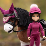 LeMieux AW26 Toy Rider Outfit Varient Blackberry. Mini action figure dressed in a blackberry outfit stood by a toy horse wearing a bridle and matching ears.