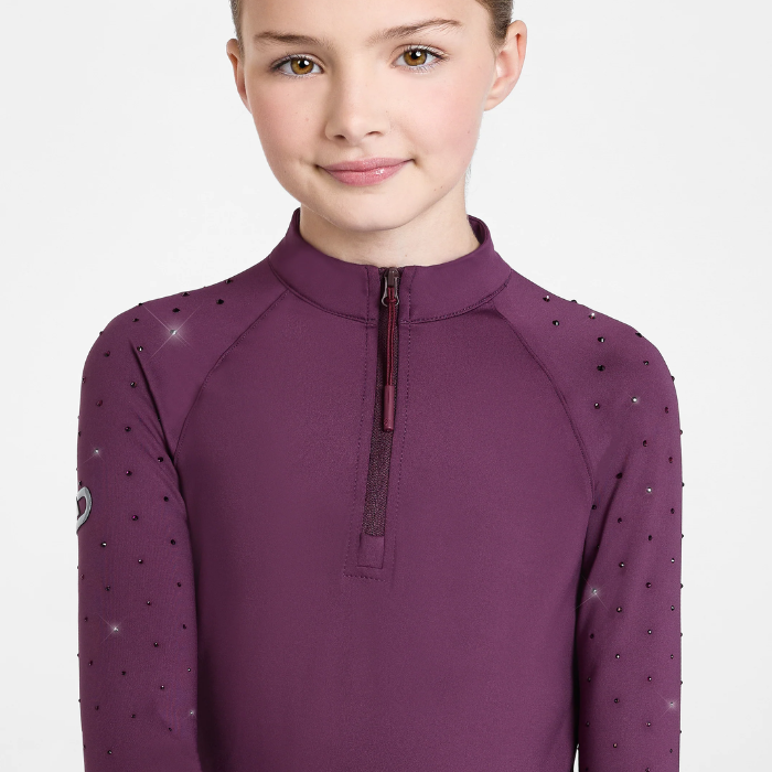 A child wearing a long-sleeve quarter-zip top in deep plum purple, featuring rhinestone embellishments along the shoulders and sleeves, set against a plain light gray background.