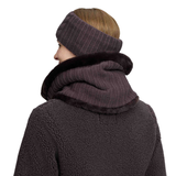 A person shown from the back wearing a dark charcoal ribbed knit headband and matching hooded scarf with a black faux-fur trim, paired with a dark fleece jacket against a plain white background.