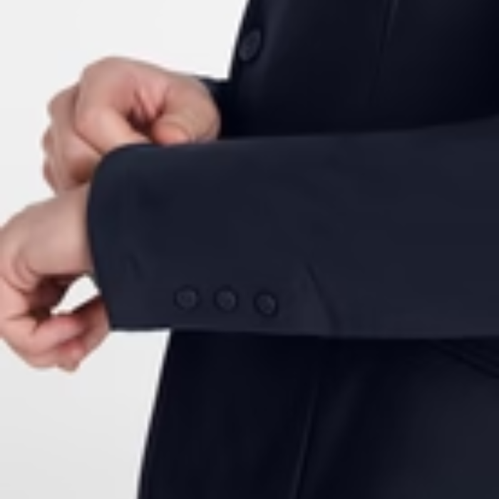Close-up of a person adjusting the cuff of a dark suit jacket on a light gray background