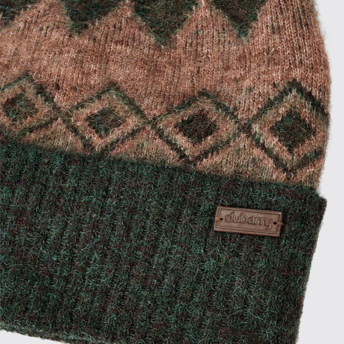 Dubarry Of Ireland Coolroe Bobble Hat Variant Olive Multi. Close-up of a knit beanie with a brown and dark green geometric pattern on the upper section and a dark green ribbed cuff. A small brown leather patch on the cuff is embossed with the brand name 'dubarry'.