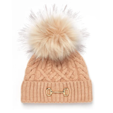Holland Cooper Horsebit Bobble Hat Variant Camel. A cable-knit beanie in a warm peach-beige color, featuring a large fluffy faux-fur pom-pom in a matching light beige tone and a gold-tone horsebit detail on the front cuff.
