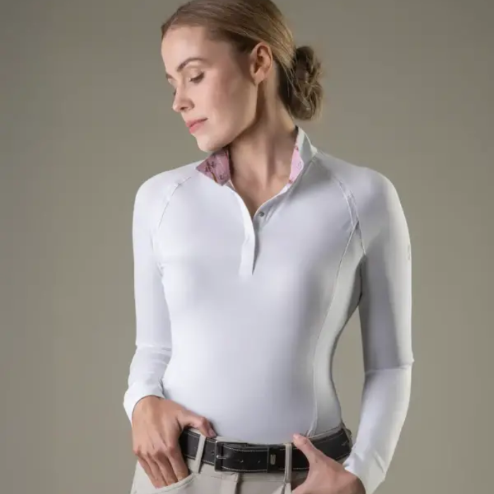 Woman wearing a white long-sleeve shirt with a patterned collar against a neutral background