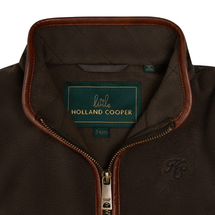 Holland Cooper Little Country Fleece Gilet Variant Khaki. Close-up of a brown fleece jacket collar with dark brown leather trim and a visible Holland Cooper brand label inside the neck.