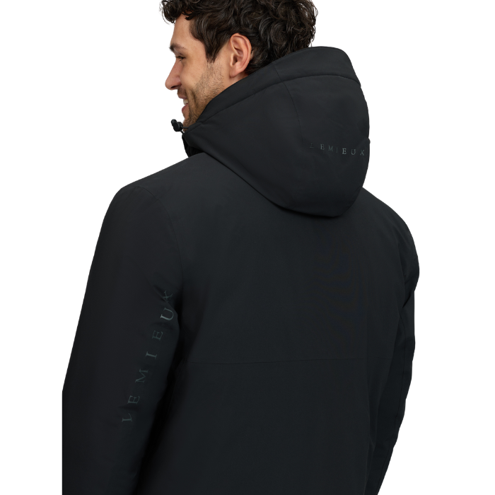 LeMieux AW26 Mens Waterproof Training Coat Varient Black. Man wearing black coat with hood and LeMieux branding from the back on a white background. 