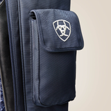 Close-up of a navy blue textured fabric bag with a front flap pocket featuring a white Ariat logo, shown against a light beige background.