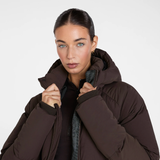 Aztec Diamond Matte Long Puffer AW26 Variant Espresso. A woman wearing a dark brown puffer jacket with a high collar, shown from the chest up against a light gray studio background.