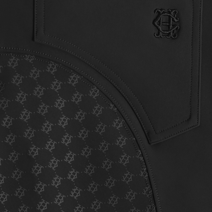 Holland Cooper Chiltern Contour Breeches Variant Colour Black.
Close up of rear of horse riding pants in black, showing a stitched pocket with an embroidered monogram logo.