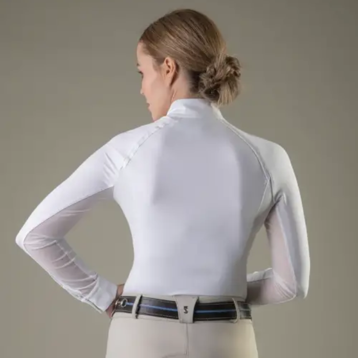 Woman wearing a white long-sleeve shirt with mesh sleeves against a neutral background
