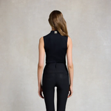 Person wearing a black sleeveless top and pants with a visible brand logo on a neutral background