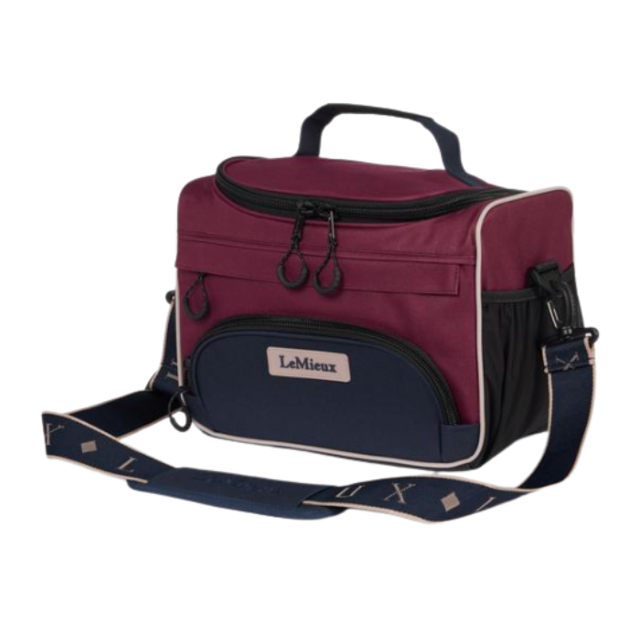 LeMieux AW26 ProKit Lite Grooming Bag Varient Blackberry. A LeMieux soft-sided cooler bag in burgundy and navy blue, featuring a top handle, a front zippered pocket with a brand label, and an adjustable shoulder strap, shown on a plain white background.