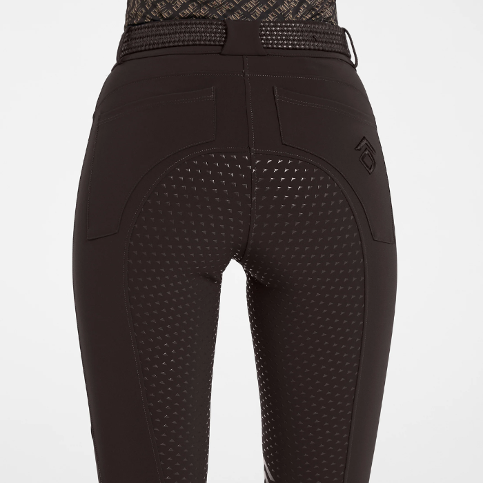Back of brown equestrian breeches with a full grip seat against a grey background. 
