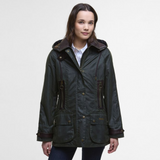 Woman wearing a dark green Barbour jacket with brown accents on a white background