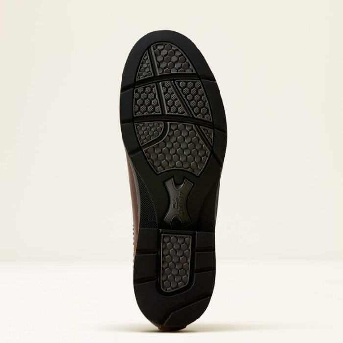 Ariat Langley H20 Variant Tobacco Brown. A close-up view of a shoe's black textured rubber outsole, showing the tread pattern and a central logo embossed, set against a plain off-white background.