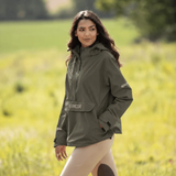 Reincoat Smock Pro Variant Olive. Lady standing in a field wearing a Olive jacket with 'REINCOAT' on the front. 