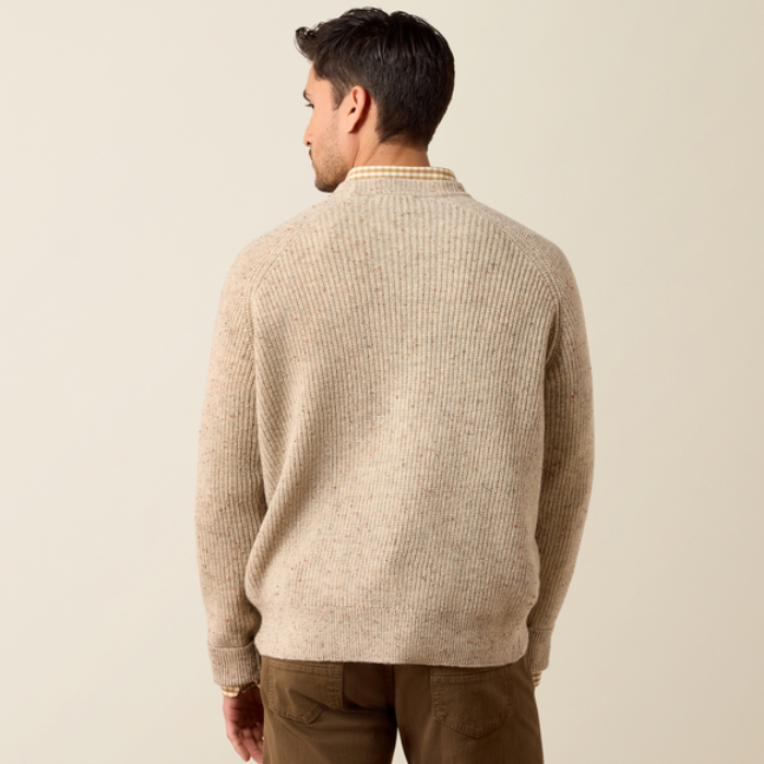 Ariat Men's Heddon Sweater Varient Oatmeal Heather. Back of man wearing a beige coloured wool jumper and brown trousers on a beige background. 