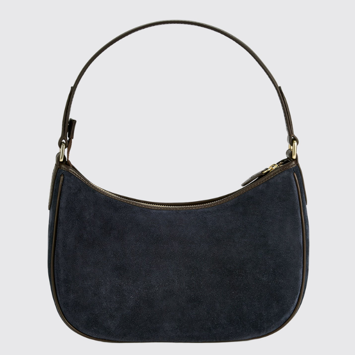 A dark navy blue suede crescent-shaped shoulder bag with gold-tone hardware and a thin dark strap, shown against a light gray background.
