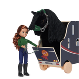 LeMieux AW26 Toy Pony Lorry Wooden Varient Brown. A doll with long red-brown hair stands beside a black horse in a small wooden cart. The horse wears a green halter, and the cart is navy with light wood wheels and trim.