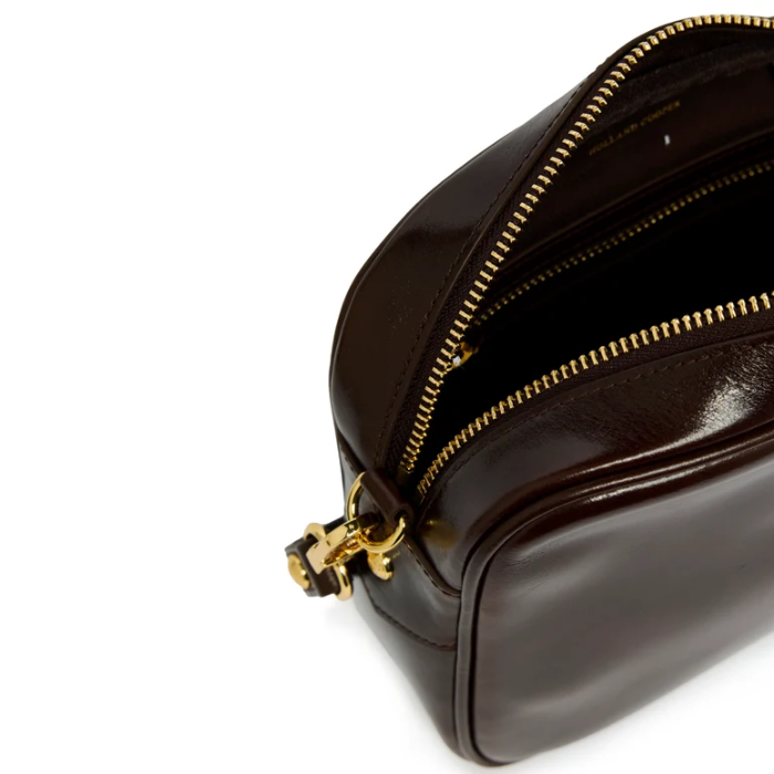 Holland Cooper Country Camera Bag Variant Chesnut Leather.  A close-up of a dark brown leather bag with gold-tone zippers and hardware, shown on a clean white background.