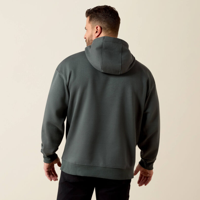 A man viewed from the back wearing a dark gray pullover hoodie with a relaxed fit, set against a plain light beige studio background.