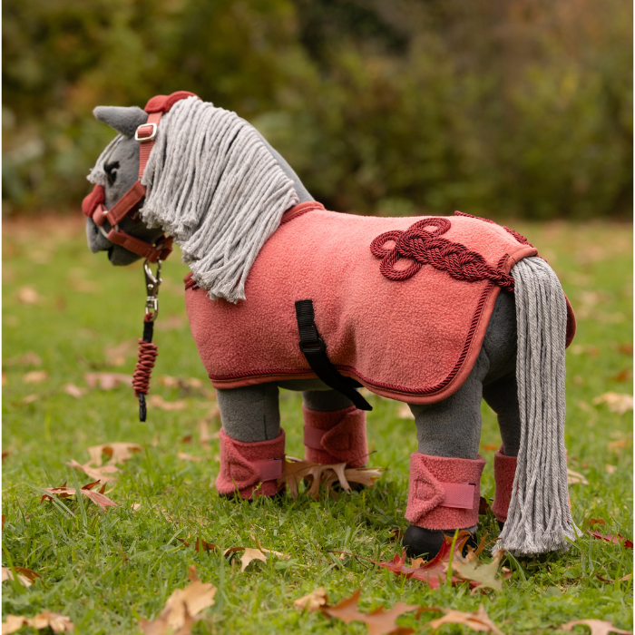 LeMieux AW26 Toy Pony Rug Variant Colour Spiced Earth. A plush toy pony wearing a spiced earth colour equestrian costume on faded grass background.