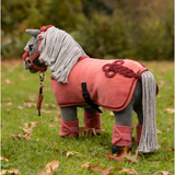 LeMieux AW26 Toy Pony Rug Variant Colour Spiced Earth. A plush toy pony wearing a spiced earth colour equestrian costume on faded grass background.