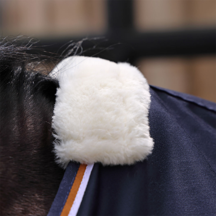 Close-up of a horse's neck with a white fake fur ribbing on a blurred background