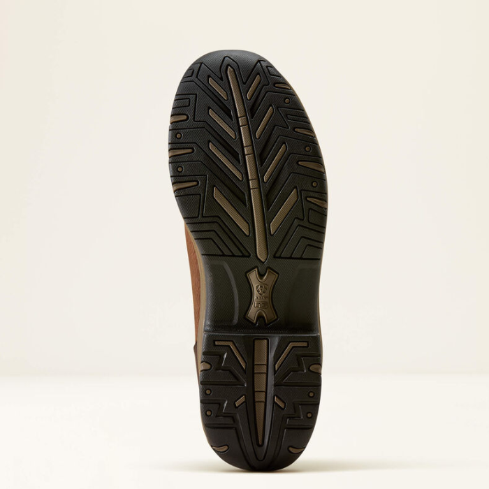 The outsole of a brown leather boot with a black and brown treaded rubber sole, shown from a top-down view on a light beige background.