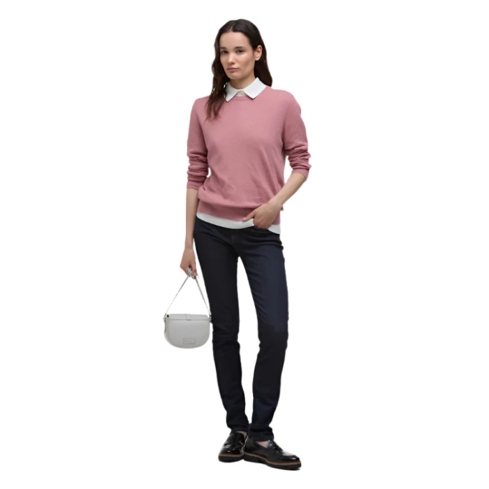 Female styles the Barbour Ladies Lavender Knitted Jumper with a crisp white shirt, dark jeans and shoes and a white bag.