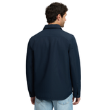 LeMieux AW26 Mens Showerproof Shacket Varient Navy. A man viewed from the back wearing a dark navy long-sleeve button-up shirt and light blue jeans, set against a plain white background.