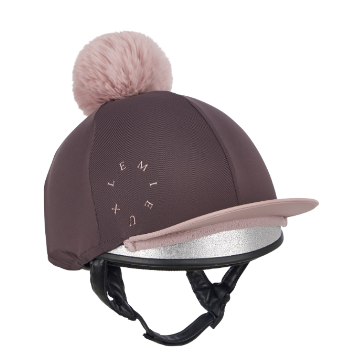 LeMieux AW26 Classique Pom Hat Silk Variant Colour Cocoa.
A  cocoa colour equestrian riding helmet cover with a matching pink faux-fur pom-pom on top and a light pink visor. The brand name 'LEMIEUX' is printed in white letters on the side, and the helmet underneath has a silver reflective visor and black chin strap.