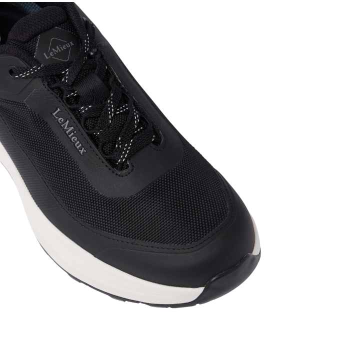 toe of navy trainer with 'LeMieux' brand and laces on white background