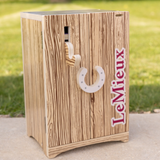 LeMieux AW26 Toy Pony Tack Locker Wooden Varient Brown. Small wooden tack box with hoof shaped handle, bridle hook and LeMieux down the side. 