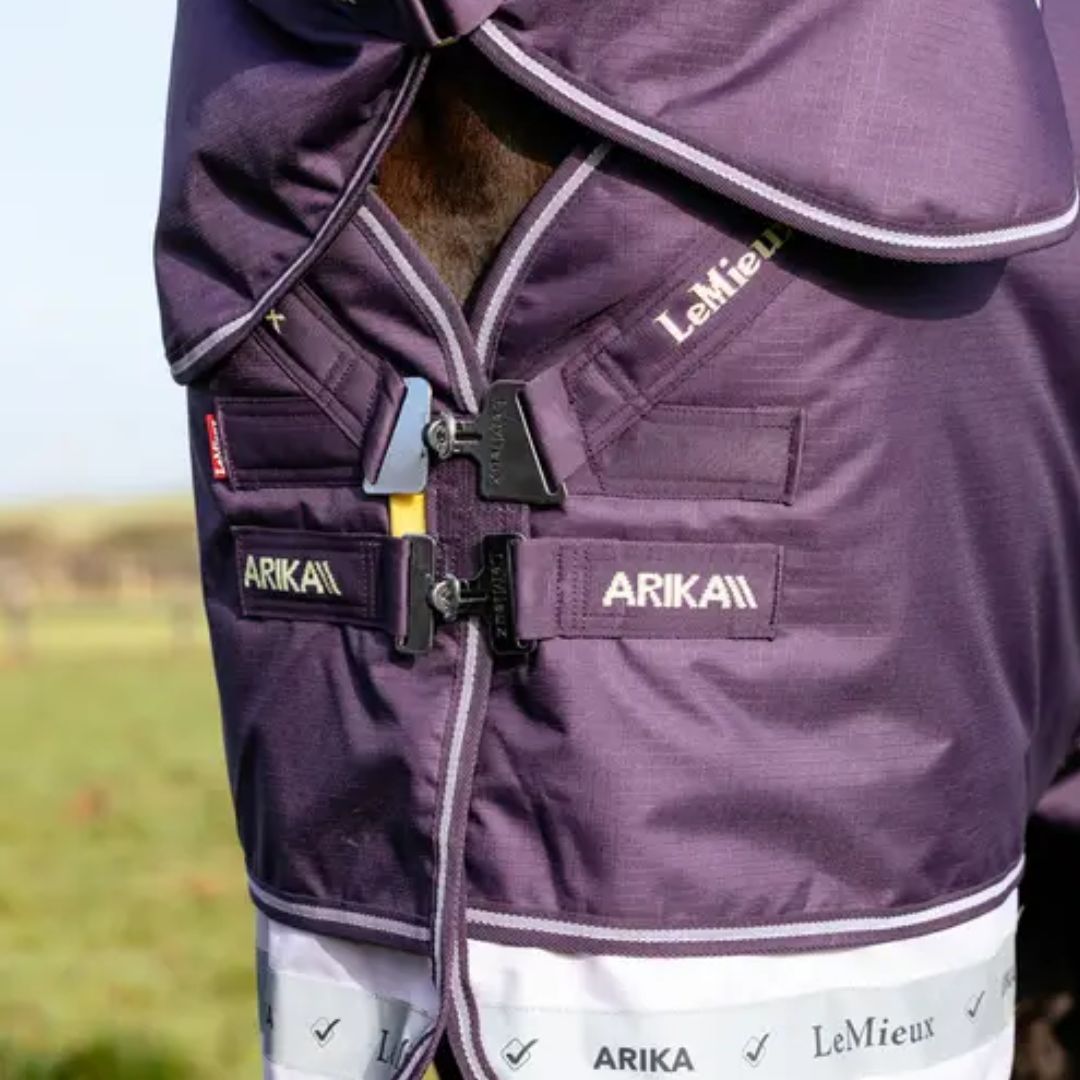 Close-up of a purple equestrian blanket with visible branding on a blurred background