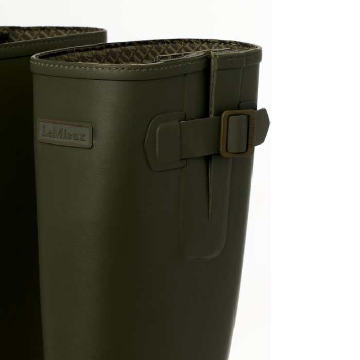LeMieux AW26 Mens Bramshaw Welly Varient Olive. Close-up of a LeMieux rain boot in olive green, showing the side strap and buckle closure, with the brand name 'LeMieux' visible.